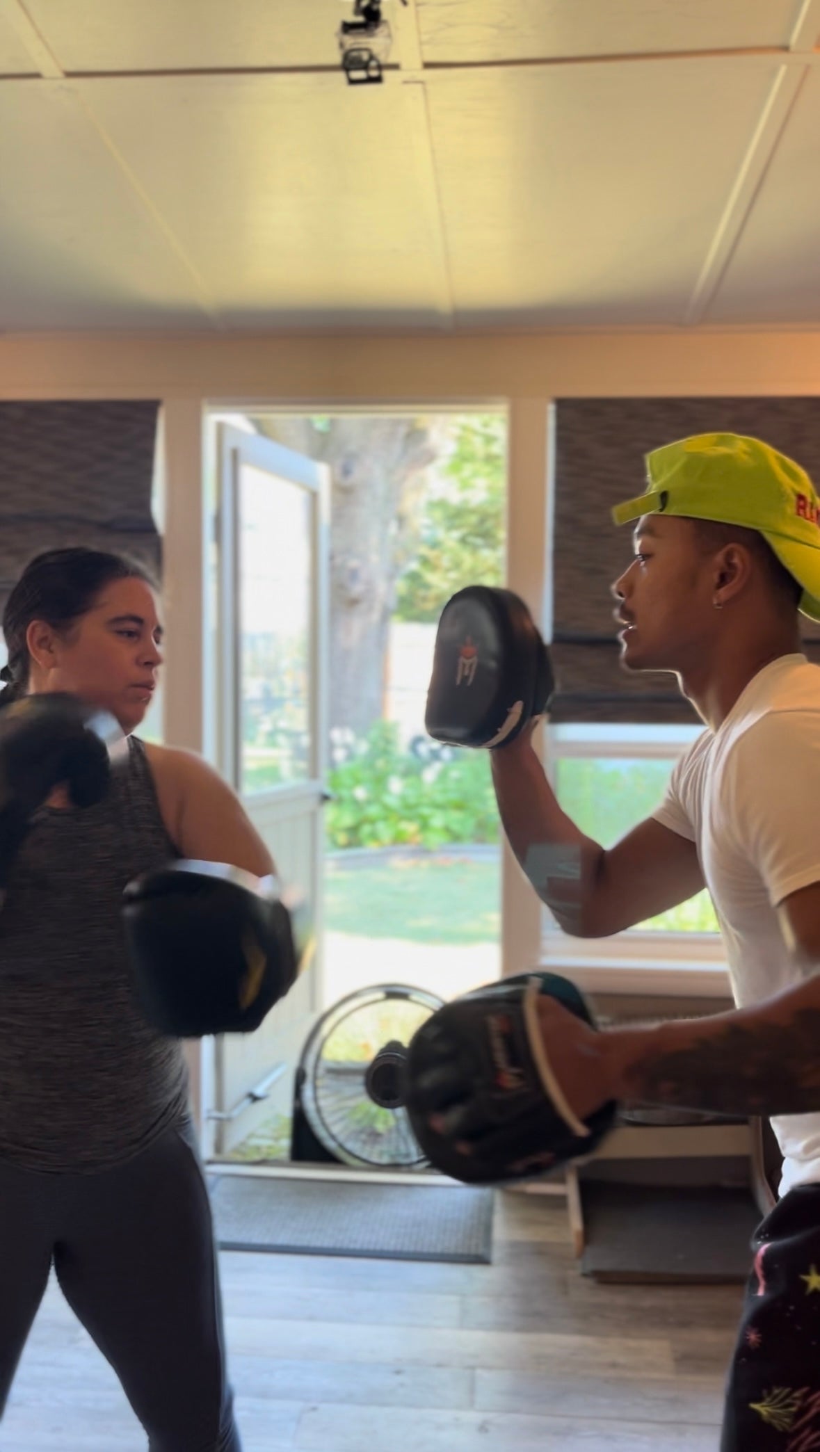 Coach Rada Rann holding focus pads for a client during a private session.